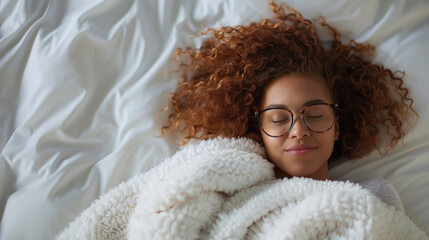 A woman is laying in bed, wrapped in a cozy blanket