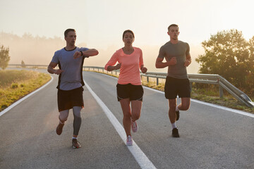 A group of friends, athletes, and joggers embrace the early morning hours as they run through the misty dawn, energized by the rising sun and surrounded by the tranquil beauty of nature