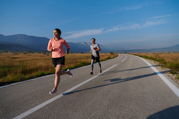 Energized by the beauty of nature, a couple powers through their morning run, their bodies and...