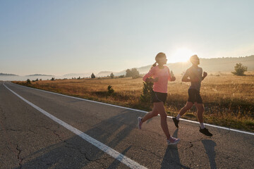 Energized by the beauty of nature, a couple powers through their morning run, their bodies and...