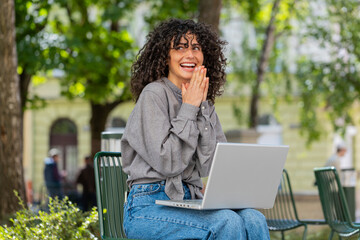 Happy Caucasian young woman working on laptop screams in triumph win celebrating good message news...