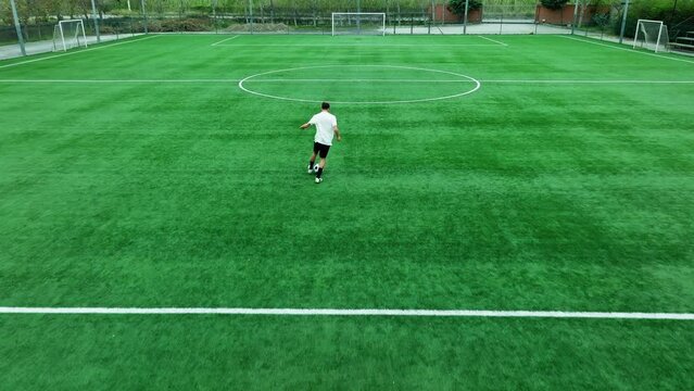 Teenage Footballer Runs Alone with Ball In The Field