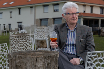 Older man enjoying a break while sitting down for a martini