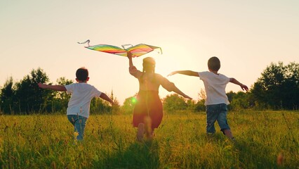 Children toy plane. Kite flies in hands of child in summer in park under sun. Children Boy, girl...