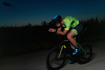 A triathlete rides his bike in the darkness of night, pushing himself to prepare for a marathon....