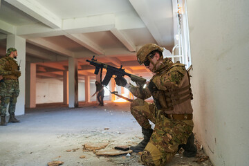 Soldier in action near window changing magazine and take cover