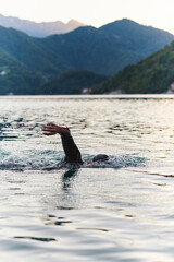 A professional triathlete trains with unwavering dedication for an upcoming competition at a lake,...