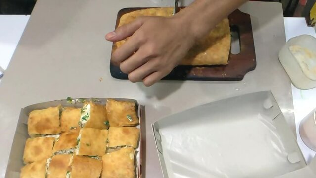 Cinematic shot. The packing process of savory pan-fried pastry famously known as Martabak Telor stuffed with eggs, meat, and onion leaf. One of the well known Indonesian Culinary Cuisine