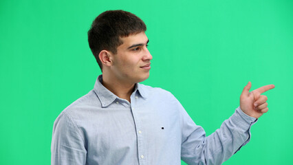 A man, close-up, on a green background, points to the side