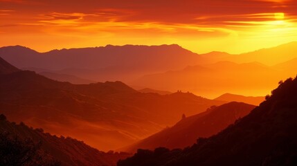A magical view of a mountain shadow creeping over the rolling hills during a fiery sunset.
