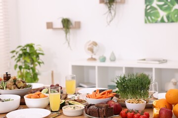 Healthy vegetarian food, glasses of juice and plates on table indoors