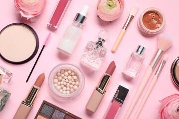 Flat lay composition with different makeup products and beautiful spring flowers on pink background
