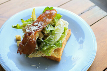 Sandwich for breakfast with cheese, bacon, tomatoes, cucumbers and lettuce in white plate. Healthy food lifestyle.  