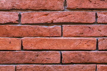 Obraz premium Red brick wall vintage texture background for interior or exterior design backdrop. Urban buildings outside.