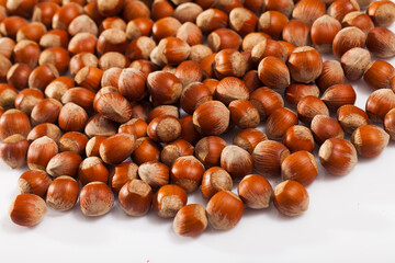 Obraz premium Unpeeled hazelnut on white surface closeup