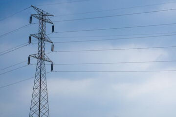 towering high voltage power pole with numerous cables stretching into the distance isolated on blue...