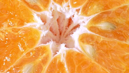 Green oranges split open, revealing vivid orange flesh against a greenish-yellow rind. Their juicy,...