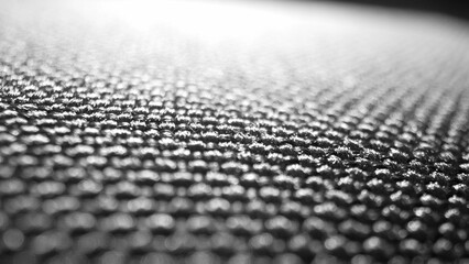 Macro lens reveals the intricate weave of black polyester, gleaming with resilience. Each fiber...