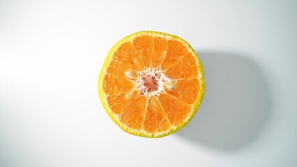 Fototapeta premium The glistening surface of this succulent orange half radiates a golden hue, its segments brimming with citrusy zest, a promise of tangy refreshment. Orange background. 