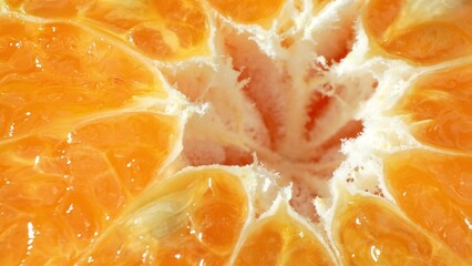 In this close-up, a halved orange shines with vivid color and luminous detail, exposing its juicy...
