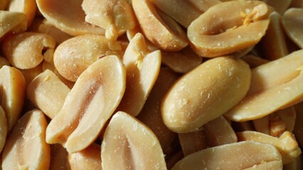 Captured in rich detail, golden-brown roasted peanuts beckon with their inviting hue. Split open, their smooth, oily texture and unique two-lobed form tantalize the senses.
