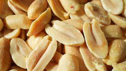 Captured in rich detail, golden-brown roasted peanuts beckon with their inviting hue. Split open, their smooth, oily texture and unique two-lobed form tantalize the senses.
