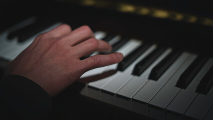 Fototapeta premium Close-up of playing piano. Media. Fingers play gracefully on piano keys. Beautiful piano keyboard playing