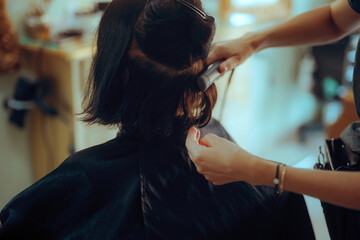 Elder woman Straightens her Hair with a Straightener at Salon. Senior lady having her hair styled...