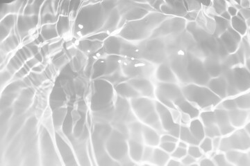 White water with ripples on the surface. Defocus blurred transparent white colored clear calm water surface texture with splashes and bubbles. Water waves with shining pattern texture background.