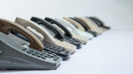 A row of vintage telephones in various colors