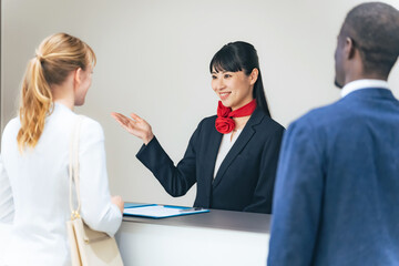 ホテルのフロントで手続きする多国籍の人々