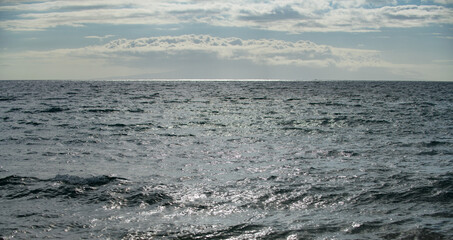 Summer sea background. Texture of water surface. Shining blue water ripple pattern.