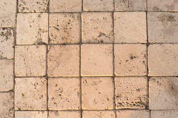 The detail of worn stone paving blocks, showcasing their texture and the subtle color variations...