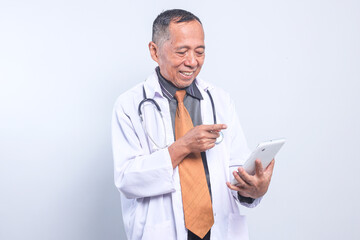 Potrait Of Happy Senior Male Doctor Pointing At Digital Tablet  Isolated On White Background