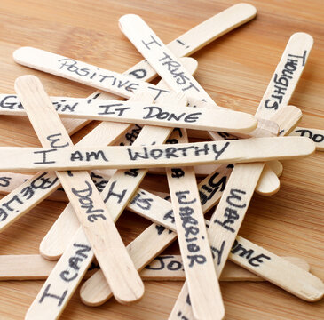 Positive Affirmations Written On Wooden Popsicle Sticks With Wooden Background