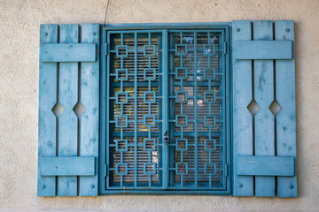 The blue window of an Iranian-style house with square grids