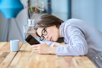 疲れた様子でスマートフォンを操作する女性