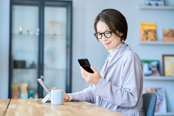 タブレットPCとスマートフォンを操作する女性