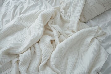 Blanket on white bed from above