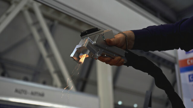Laser removes rust on metal. Media. Hand gun with laser removes rust on metal. Laser with beam removes metal rust on parts