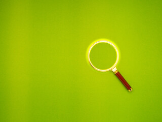 Magnifying glass on a green background.