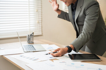 Asian businessman working on computer looking at documents at office.