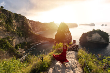 Young woman traveler enjoying and looking beautiful sunrise at Thousand island viewpoint in Nusa...