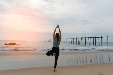 Yoga Meditation woman on the ocean during amazing sunset. Fitness and healthy lifestyle.