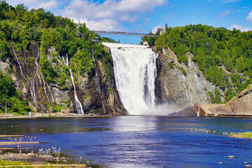 Magnificent view of the Montmorency Falls and the suspension bridge on a bright summer day with...