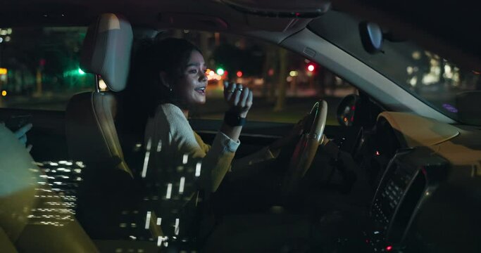 Happy woman, driving and singing with car at night for music in cruise, transportation or commute. Female person or driver in relax or enjoying late evening in vehicle for fun travel in an urban town