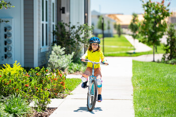 Child riding bicycle. Little kid boy in helmet on bicycle along bikeway. Happy cute little boy riding bicycle in summer park. Child in protective helmet for bike cycling on bicycle. Kid riding bike.