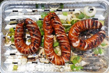 Grilling bratwurst sausages over flaming grill. Bearbeque outdoors. Barbecue Picnic