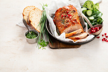 Sliced baked ham with salad on light wooden background. Traditional food concept