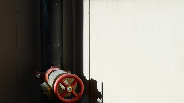Close-up of a red valve pipe in bright sunlight